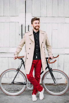 Man standing in a front of a bicycle.