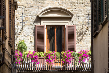 Fototapeta na wymiar Brick house with flowers and balcony in Florence, Italy