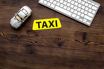 app for order a taxi online with car toy and keyboard on wooden background top view space for text