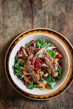 Rustic beef and kale salad on wooden background,with room for text.