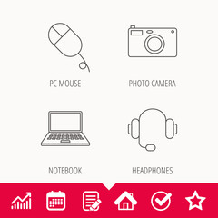 Photo camera, headphones and notebook laptop.