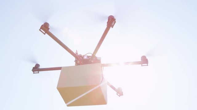 CLOSE UP LENS FLARE: UAV drone delivery. Multicopter rising and flying with package. Drone delivering goods to your home. Futuristic shipment by helicopter drone. Multirotor logistics and transport