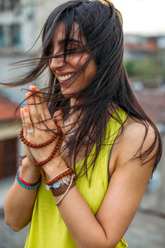 Smiling young woman with hands clasped