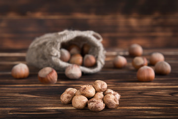 Hazelnuts on a wooden table in linen bags, walnut brushed in the foreground