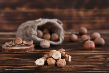 Hazelnuts on a wooden table in linen bags, walnut brushed in the foreground