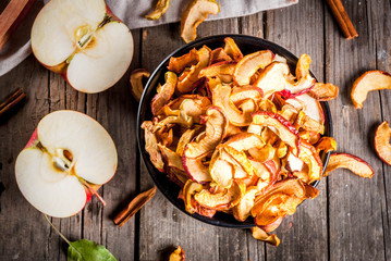 Homemade sun-dried organic apple slices, crispy apple chips, on an old rustic wooden table with...