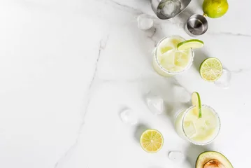  Alcoholic cocktail recipes and ideas. Avocado and lime margarita with salt, on a white marble kitchen table. Copy space top view © ricka_kinamoto