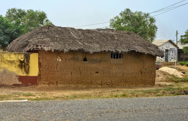 Fototapeta na wymiar African village. Traditional clay house with thatched roof. Rural area.