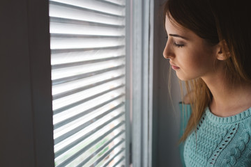 Young Woman Looking Through the Window