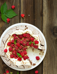 Chocolate dessert (pie) of pavlov with cream and raspberries.