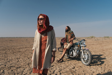 Young Couple Traveling Through Desert on Motorbike