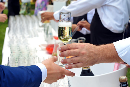 Pass the glass of Champagne. Party. Catering. Hand
