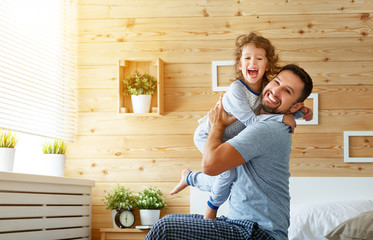 happy family father and   daughter reading book in bed.