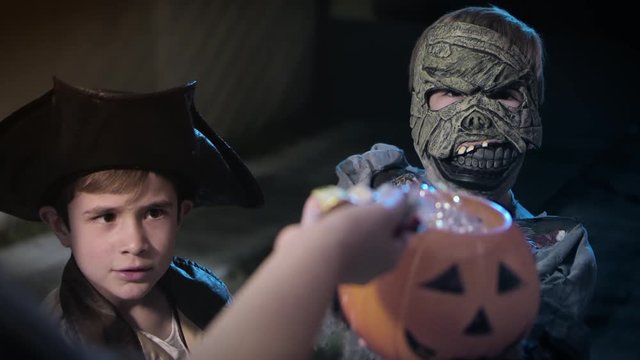kids playing trick or treat on halloween