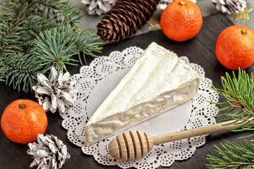 Brie cheese tangerine tree branches and a wooden spoon for honey