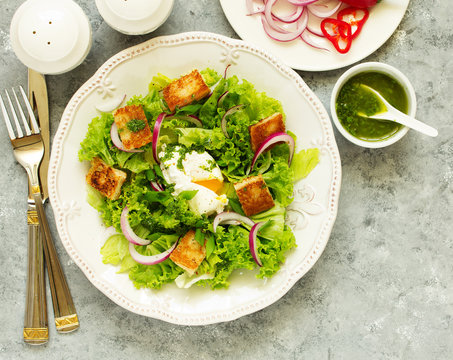 Spring salad with poached egg and crispy croutons. View from above.