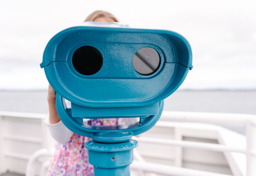 girl using a viewfinder telescope on a ferry trip
