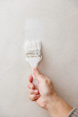 Painting roller in worker's hand. Repair in a room. Painting of walls