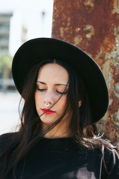 Portrait of a young alternative woman with a nose ring and red lips.