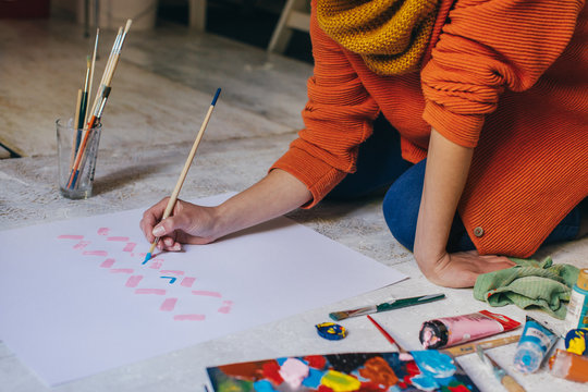 Female Artist Painting on Floor