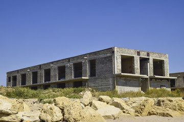 Fototapeta na wymiar Unfinished building of gray block