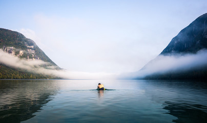 early morning swim in a foggy lake