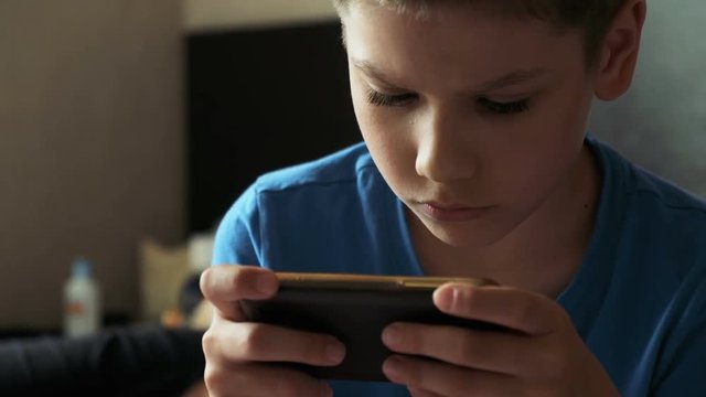 Child with mobile phone indoors. Portrait of boy with mobile phone. Growing up technology addiction concept use smartphone app for online browsing or watch video