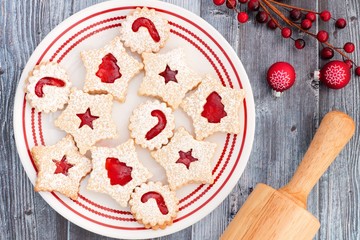Christmas jam filled cookies, overhead scene on a rustic old gray wood background