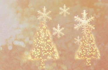 light golden of Christmas tree and snow flake glitter greeting background
