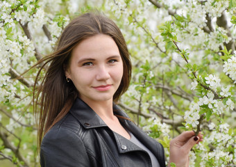 Beautiful fairy young girl in a flowering plum garden. Portrait