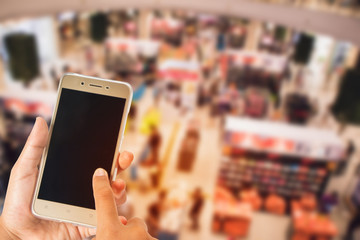 people's hands playing a mobile phone  in the mall.