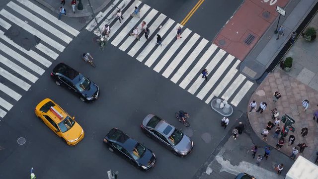 A high angle, slow motion view of pedestrians and traffic on 5th Avenue in midtown Manhattan.  	