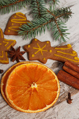 Dried orange, spices and decorated gingerbread on rustic board, Christmas time concept