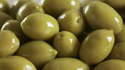 Large shiny green olives macro background