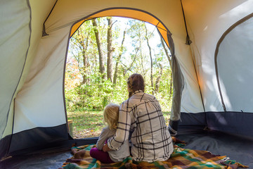 Mom and daughter camping in autumn - back view - obrazy, fototapety, plakaty