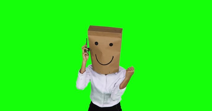
Unknown businesswoman with a paper bag on her head, making a phone call and listen a good news while expressing her success. Shot in 4k resolution