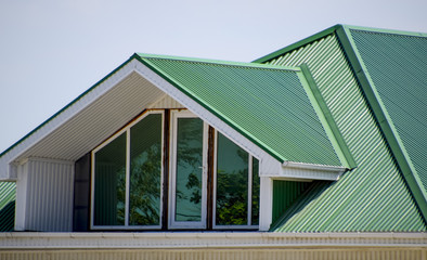 The house with plastic windows and a green roof of corrugated sh