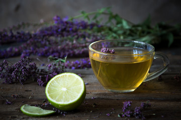 Green tea with herbals and lime. Tea with oregano on the wooden background