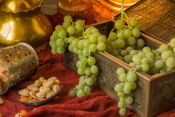 Traditional oriental sweets, nuts and grape. Metal and copper kitchen tools