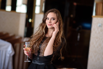 A beautiful girl in a restaurant communicates by phone.
