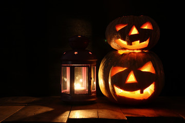 Halloween Pumpkin on wooden table in front of spooky dark background. Jack o lantern