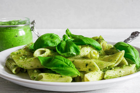 penne pasta with basil pesto and herbs in a plate