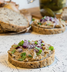 pork spread, lard and sour cucumbers on fresh round bread, sprinkled with spring and red onion