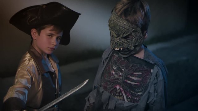 Halloween. 2 kids knocking the door, doing trick or treat. One zombie and pirate
