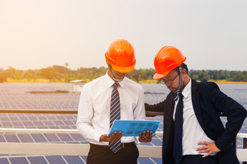 engineering team working on checking and maintenance equipment at solar power plant; senior engineer coaching and consult to junior engineer for performance of operation