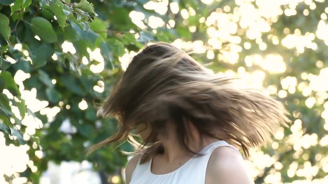 young girl smiling twists head and her hair fly away in slow motion