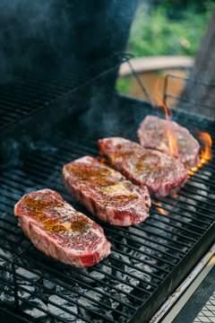 Steak cooking over charcoal grill