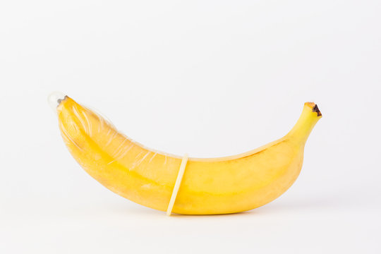Condom and banana on a white background close-up