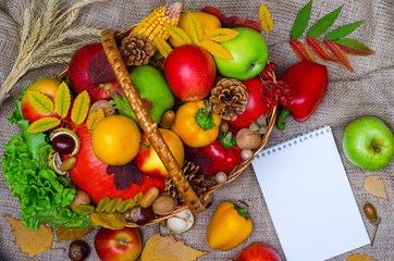 Autumn composition: wicker basket with fruits and vegetables top view.