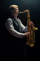 Fototapeta premium Young man playing the Saxophone